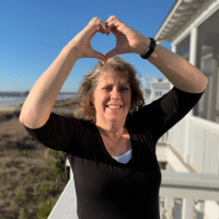 smiling woman making heart shape with hands